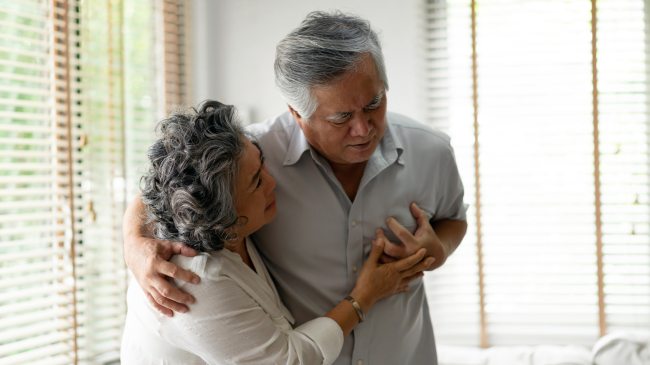 A woman helping a man suffering from congestive heart failure symptoms