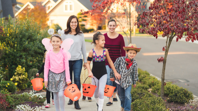 Two women walking with children to ensure a safe Halloween